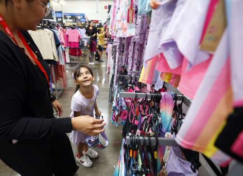 Volunteers help children pick out clothes during back-to-school shopping event in Elgin