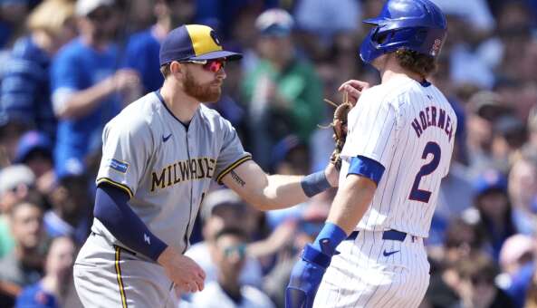 Milwaukee Brewers' Oliver Dunn, left, tags out Chicago Cubs' Nico Hoerner between second and third during the fifth inning of a baseball game Friday, May 3, 2024, in Chicago. (AP Photo/Charles Rex Arbogast)