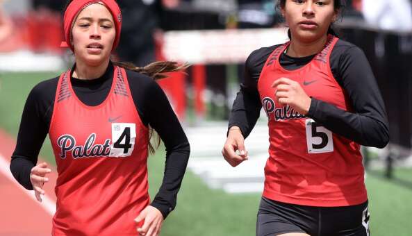 Palatine’s Roxy Soto, left, and Jocelyn Huila Cortes run beside one another in the 1,600-meter run during Saturday’s girls track meet at Palatine High School.