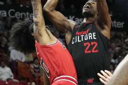 Miami Heat forward Jimmy Butler (22) goes to the basket as Chicago Bulls guard Coby White (0) defends during the first half of an NBA basketball game, Saturday, Dec. 16, 2023, in Miami. (AP Photo/Lynne Sladky)