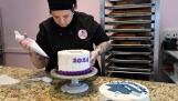 Owner Tammy Montesinos decorates a graduation cake at Sweet T’s Bakery on Thursday in Arlington Heights.