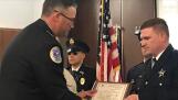 Palatine police officer Shane Murray, right, receives the Lifesaving Award from police Chief William Nord at Monday's village council meeting.
