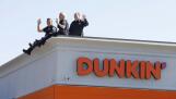 Schaumburg officer Eric Wang, from left, officer Emily Zuhr, and Lt. Elliot Rose wave to cars on Friday during the Dunkin’ Cop On a Rooftop 2024 for Special Olympics in Schaumburg.