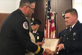 Palatine police officer Shane Murray, right, receives the Lifesaving Award from police Chief William Nord at Monday's village council meeting.
