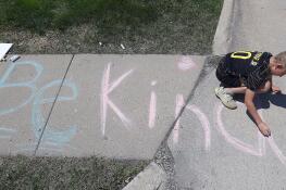 Queen of the Rosary School fourth grader Charles Gura, 10, finishes up his “Be Kind” message in chalk on the sidewalk outside the Elk Grove Village school Wednesday. It’s part of Community Character Coalition of Elk Grove-sponsored “Chalk It Up To Character” week.