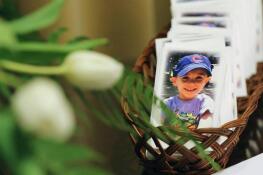 Prayer cards for AJ Freund, 5, sit on a table next to the visitor guest book on May 3, 2019, during a memorial service at Davenport Funeral Home in Crystal Lake.