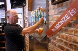 Brewmaster Ryan Clooney pours a beer last Friday at Crystal Lake Brewing. The brewery is celebrating its 10th anniversary and recently won a bronze award in Brown Porter category at the World Beer Cup in Las Vegas.