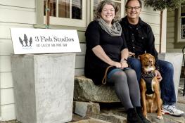 Husband-and-wife artist team Annie Galvin, left, and Eric Rewitzer pose with their dog Woody in front of their new 3 Fish Studios art gallery in Amador City, California, in 2023. Galvin and Rewitzer moved out of San Francisco to live closer to nature after their sabbatical in France and Ireland.