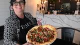 Maria Morales holds the Tievoli pizza at Tievoli Pizza Bar on Tuesday in Palatine.