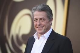 Hugh Grant says he received “an enormous sum of money” to settle a lawsuit accusing the publisher of The Sun tabloid of unlawfully tapping his phone, bugging his car and breaking into his home to snoop on him.