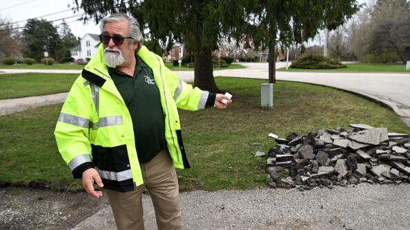 Dan Peterson, Prospect Heights’ building &amp; development director, shows an example of what’s left after a driveway paving scam. Officials say they’ve seen a surge in such scams across the suburbs.