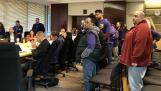 Tollway employees stand as a co-worker talks about layoff concerns at a board meeting Thursday.