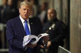 Former President Donald Trump speaks with the media while holding news clippings following his trial at Manhattan criminal court in New York on Thursday.