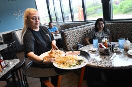 Lily Parra serves customers their food at Sweet Basil Cafe, which opened Monday in Hanover Park’s Westview Center on Barrington Road.