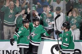 Dallas Stars center Wyatt Johnston, center, celebrates his first period goal with Joe Pavelski (16) and Miro Heiskanen (4) Sunday during Game 7 against the Vegas Golden Knights in Dallas.
