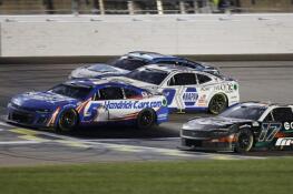 Kyle Larson (5) crosses the finish line milliseconds in front of Chris Buescher (17) for the win Sunday during a NASCAR Cup Series auto race at Kansas Speedway in Kansas City, Kansas.