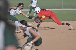 Mundelein’s Taylor Pyke dives safely into third base as Stevenson’s Jasmine Lucero is pulled off the bag by a wide throw last week. Mundelein won as part of a 23-0 start to the season.