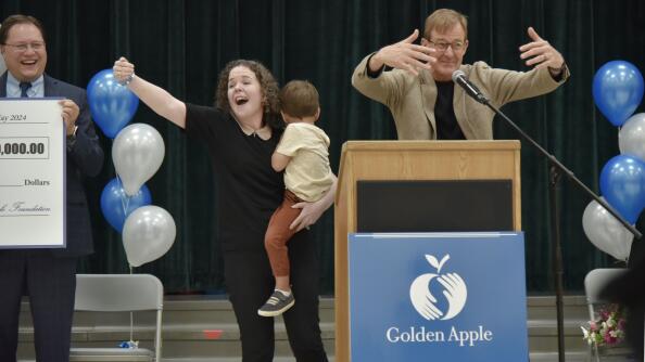 Plainfield Elementary School Principal Lisa Carlos, center, celebrates Monday with her students and staff at the Des Plaines school as she is introduced as winner of the Golden Apple award for Excellence in Leadership. Announcing the award is, at right, Alan Mather, president of the Golden Apple Foundation.
