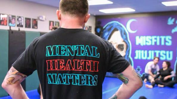 Brad Edmondson, the owner and operator of The Misfits Jiujitsu of St. Charles, wearing one of his Misfits T-shirts reading “Mental Health Matters."