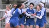 Wheaton North teammates surround Jane Rogers after her first-half score against St. Charles North last month in Wheaton. The Falcons are 11-3-2 on the season.