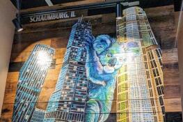 A mural of a koala climbing the Willis Tower in Chicago is among the eye-catching artwork at Outback Steakhouse's relocated and redesigned Schaumburg restaurant.