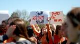 Batavia High School sophomore Emme Stawniak holds up a sign among hundreds of classmates during a walk-out organized by the school’s Students Against Gun Violence club on Friday.